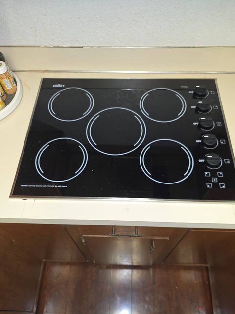 Summit five-burner ceramic cooktop set into a laminate counter, element test in progress