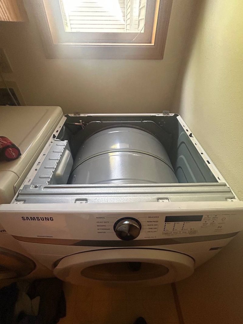 Samsung dryer with the top panel lifted and the drum exposed for a roller and belt repair